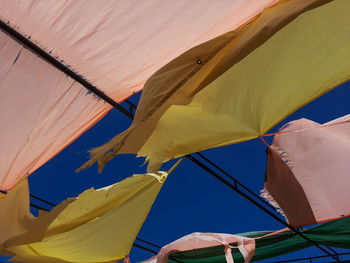 Low angle view of flags against blue sky