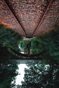 Upside down image of man on railroad tracks