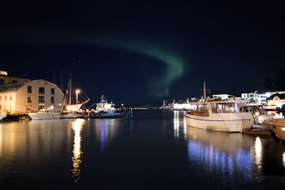 Boats moored in sea against sky at night