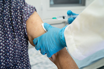 Midsection of woman holding syringe