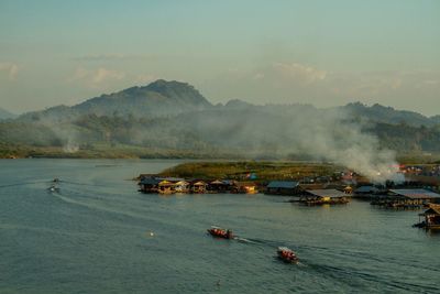 High angle view of boats in sea against mountains