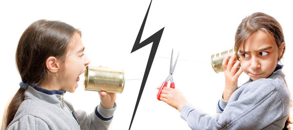 Digital composite image of girls using tin can phone against white background