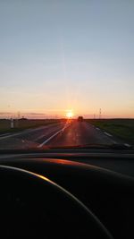 Road passing through sunset