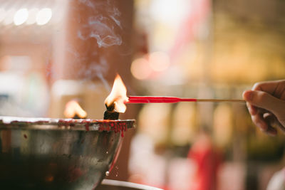 Close-up of hand holding burning candle