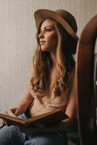 Beautiful young woman sitting in hat