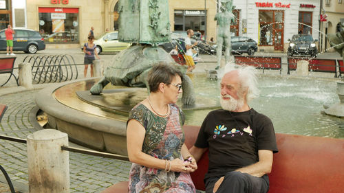 Couple sitting on water at park