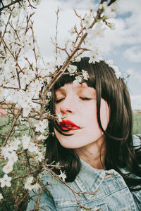 Portrait of young woman with red flowers