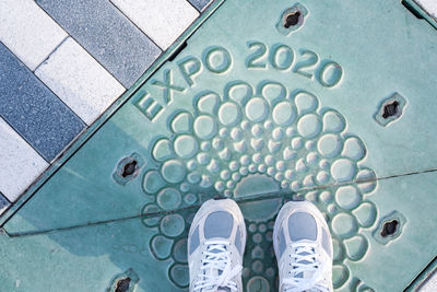 Low section of person standing on tiled floor