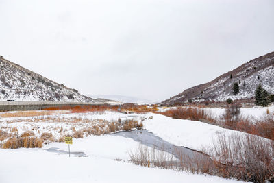 Snow covered landscape against sky