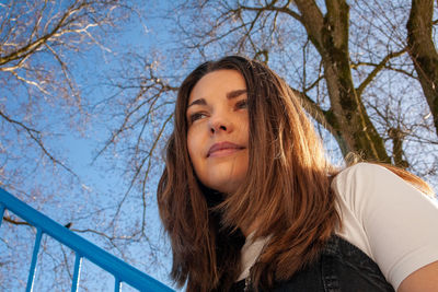 Portrait of a smiling young woman against trees