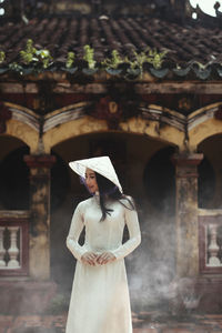 Woman standing against building