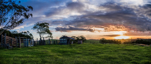 Barn on field against sky during sunset