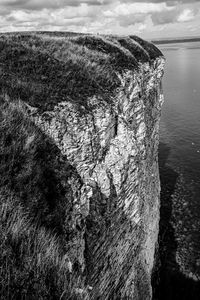 View of rock formation in sea against sky