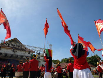 Group of people in traditional flags against sky