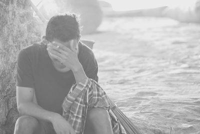 Man covering face while sitting in boat