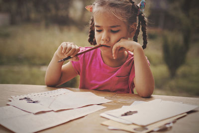 Cute girl brainstorming while doing homework