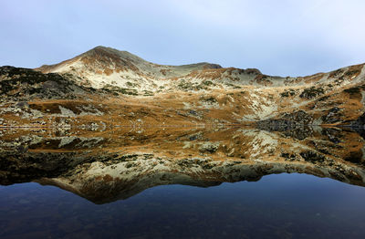 Idyllic shot of lake and mountains against sky