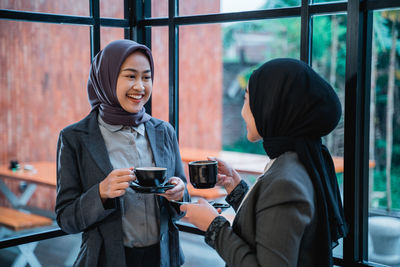 Young woman using mobile phone in cafe