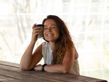 Young woman using smart phone while sitting on camera