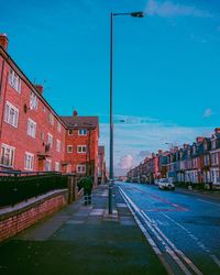 Road in city against blue sky