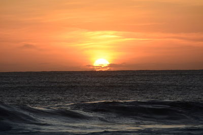 Scenic view of sea against orange sky