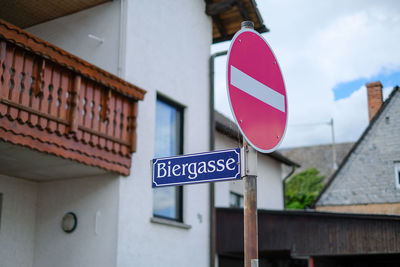 Low angle view of road sign against building