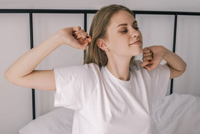 Waking up in the morning. young sleepy woman stretches out in bed with her eyes closed 