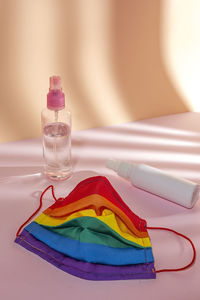 Close-up of drinking mask with hand sanitizer on table