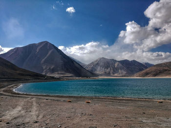 Scenic view of sea and mountains against sky