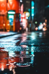 Illuminated city street during rainy season at night