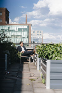 Businessman relaxing in his urban rooftop garden