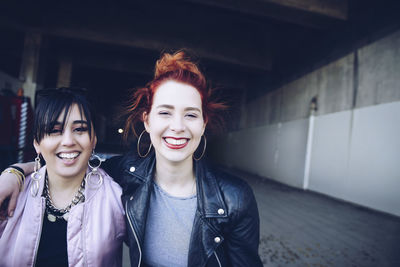 Portrait of smiling hipster female friends at parking lot
