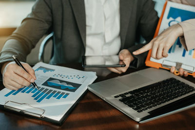 Midsection of man using laptop on table