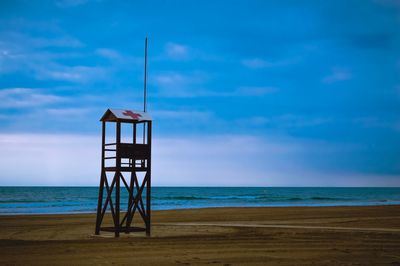 Lifeguard hut on beach against sky