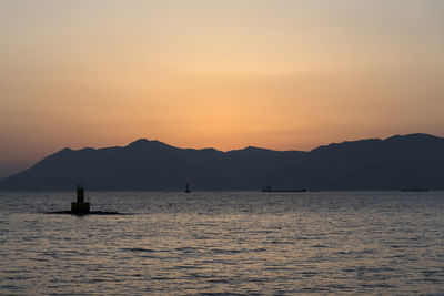 Silhouette sailboats in sea against sky during sunset