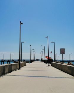 People on street against clear blue sky