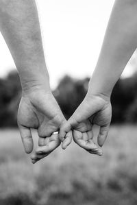 Cropped image of couple holding hands outdoors