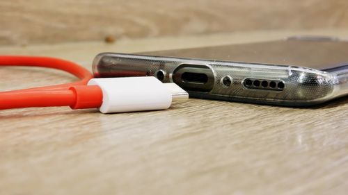 Close-up of mobile phone and charger on table