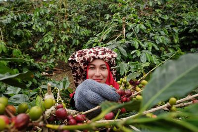 Portrait of smiling woman against clear plants