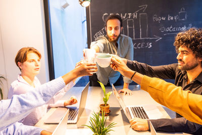 Friends using mobile phone while sitting on table