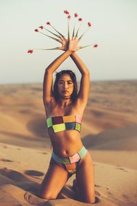 Portrait of sensuous female model posing in bikini at desert