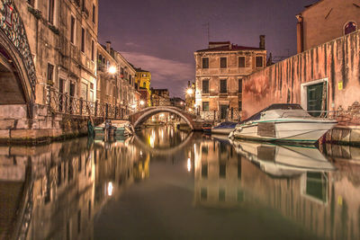 Boats moored in river against buildings