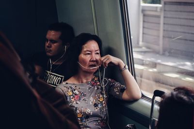 Young man using mobile phone while sitting in bus