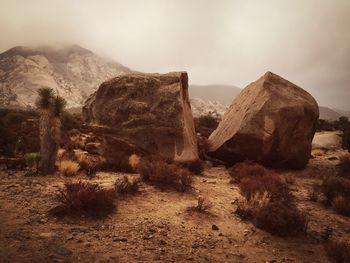 Rock formations and mountains against cloudy sky at joshua tree national park