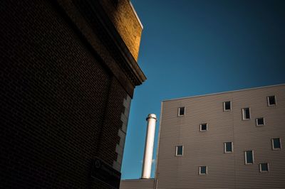 Low angle view of office building against clear blue sky