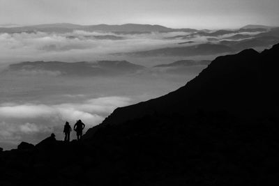 Silhouette of people on mountain