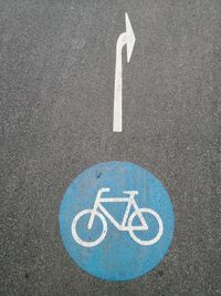 High angle view of arrow and bicycle signs on road