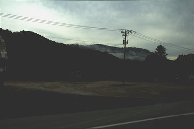 Silhouette of mountain range against cloudy sky