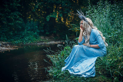 Portrait of young woman standing in forest