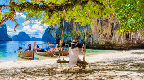 Rear view of woman sitting on beach